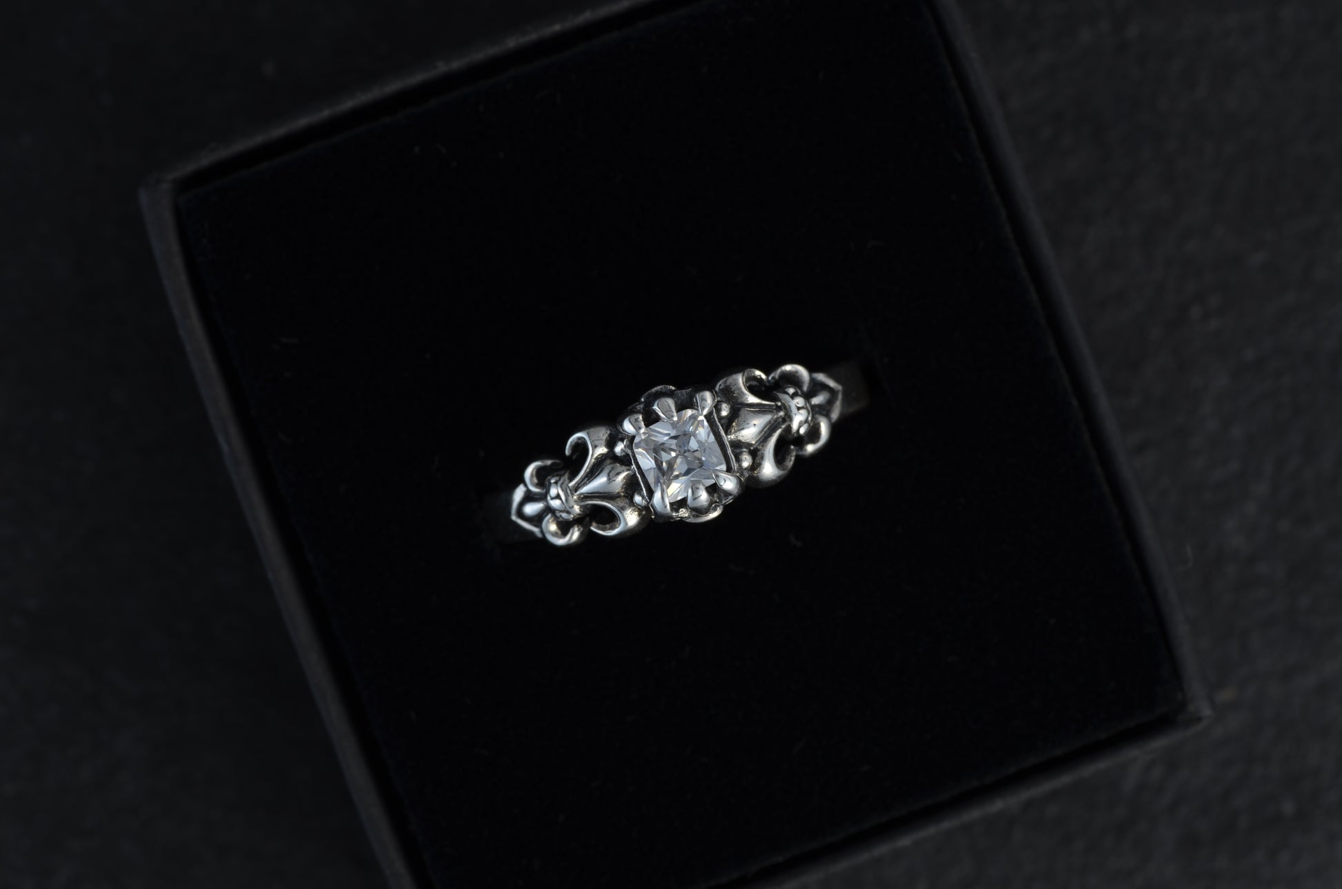 Fleur-de-lis Ring mit weißem Stein